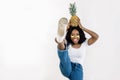 Portrait of a beautiful exotic young african woman wearing jeans and t-shirt, standing isolated over white background Royalty Free Stock Photo