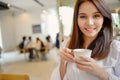 Portrait of beautiful woman and holding a cup of coffee in her hand on blur background coffee shop