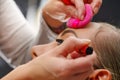 Portrait of beautiful face of young woman getting make-up. The artist is applying eye mascara on her eyes. The lady Royalty Free Stock Photo