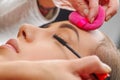 Portrait of beautiful face of young woman getting make-up. The artist is applying eye mascara on her eyes. The lady Royalty Free Stock Photo