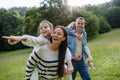 Portrait of beautiful family, parents piggibacking two daughters, having fun in nature.