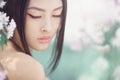 Portrait of a beautiful fantasy asian girl outdoors against natural spring flower background. Royalty Free Stock Photo