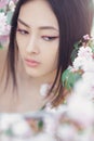 Portrait of a beautiful fantasy asian girl outdoors against natural spring flower background. Royalty Free Stock Photo