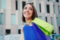 Portrait of beautiful fashion woman going shopping carrying colorful paper bags walking and looking up with a smiley Royalty Free Stock Photo