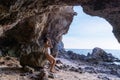 Portrait of beautiful fashionable woman in white bikini posing at the rock beach. Young Asian woman dressed in swimsuit standing Royalty Free Stock Photo