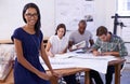 Our new designs are gonna rock. Portrait of a beautiful female architect and her colleagues working in the background. Royalty Free Stock Photo