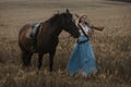 Portrait of a beautiful female cowgirl with shotgun from wild west riding a horse in the outback.