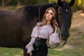 Portrait of a beautiful female cowgirl with shotgun from wild west riding a horse in the outback Royalty Free Stock Photo