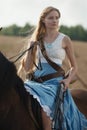 Portrait of a beautiful female cowgirl with shotgun from wild west riding a horse in the outback. Royalty Free Stock Photo