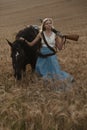 Portrait of a beautiful female cowgirl with shotgun from wild west riding a horse in the outback. Royalty Free Stock Photo