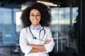 Portrait of beautiful female doctor inside office of modern clinic, female doctor smiling and looking at camera with Royalty Free Stock Photo