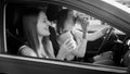 Portrait of beautiful female driver drinking coffee while driving a car with her girl friend Royalty Free Stock Photo