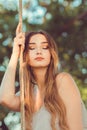 Portrait of beautiful female face near ropes of swing, girl swinging on nature, young pensive romantic woman, solitude, lifestyle Royalty Free Stock Photo