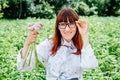 Portrait of a beautiful female farmer holding a organic young garlic, smiling at the camera and surrounded by plenty of plants in Royalty Free Stock Photo