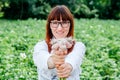 Portrait of a beautiful female farmer holding a organic young garlic, smiling at the camera and surrounded by plenty of plants in Royalty Free Stock Photo