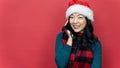 Portrait of beautiful female model wear santa hat isolated over red background. Concept of the New Year and Christmas Day Royalty Free Stock Photo