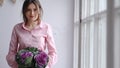 Portrait of a beautiful florist with a violet bouquet of unusual flowers - brassica. Look in the camera.