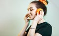 Portrait of beautiful funny girl with orange halves like headphones for listening to music, woman fooling around, concept music of Royalty Free Stock Photo