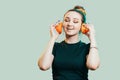 Portrait of beautiful funny girl with orange halves like headphones for listening to music, woman fooling around, concept music of Royalty Free Stock Photo