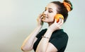 Portrait of beautiful funny girl with orange halves like headphones for listening to music, woman fooling around, concept music of Royalty Free Stock Photo