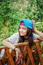 Portrait of a beautiful girl in a baseball cap on the background of a green garden on a summer day Royalty Free Stock Photo