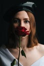 Portrait of a beautiful girl in a black beret. A young girl in the studio in the image of a Parisian woman with a red