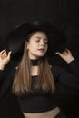 Portrait of beautiful girl in black top and wide-brimmed hat. Stylish young lady. Vertical frame Royalty Free Stock Photo