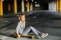 Portrait of a beautiful girl with blond hair on a skateboard. Soap bubbles in the air Royalty Free Stock Photo