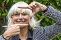 Portrait of a beautiful girl with blonde wig while self-framing her face with her fingers Royalty Free Stock Photo