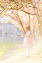 Portrait of beautiful girl with blooming flowers. Cherry blossom. Little caucasian girl with long blonde hair standing in the park Royalty Free Stock Photo