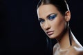 Portrait of beautiful girl with blue bright make-up in long earrings