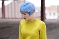 Portrait of beautiful girl with blue hair and red lips in a yellow sweater at the construction site Royalty Free Stock Photo