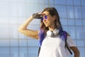 A portrait of beautiful girl with blue hair, blue sunglasses with headphones and roller skate protection holding a hand visor Royalty Free Stock Photo