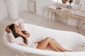 Portrait of a beautiful girl in the boudoir who lies in the bath