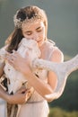 Portrait of beautiful girl brunette bride in white dress is made of tulle, decoration for hair on the head, looks straight lips