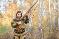 Portrait of a beautiful girl in camouflage hunter with shotgun