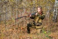 Portrait of a beautiful girl in camouflage hunter with shotgun