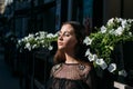 Portrait of a beautiful girl, close-up face near white flowers, brunette girl, closed her eyes. black clothes Royalty Free Stock Photo