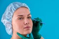 Portrait of a beautiful girl close-up, with smooth skin, hands holding a scalpel in the face with gloves. Concept beauty