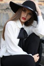 Portrait of beautiful girl with dark hair in elegant blouse and hat Royalty Free Stock Photo