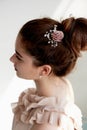 Portrait of beautiful girl with dark hair and light porcelain skin. Hair in a bun.Hair accessory handmade