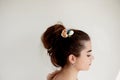 Portrait of beautiful girl with dark hair and light porcelain skin. Hair in a bun.Hair accessory handmade