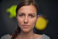 Portrait of a beautiful girl on a dark soft coloured background, which with a serious face