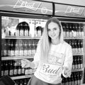 portrait of a beautiful girl in the department store on sale Beer `Bud`. Beer `Bud`, one of the most popular beers in the US Royalty Free Stock Photo