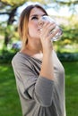 Portrait of beautiful girl drinking water glass at green park. Royalty Free Stock Photo