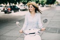 Portrait of a beautiful girl drive on retro scooter, smiling and looking at the camera Royalty Free Stock Photo