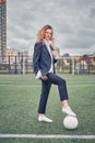 Portrait of  beautiful girl football player in man`s suit on soccer field with ball Royalty Free Stock Photo