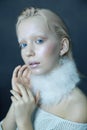 Portrait of a beautiful girl in the frost on his face on a blue ice background