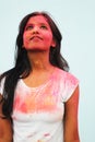 Portrait of a beautiful girl full of colored powder all over the body. Young girl plays with colors on the occasion of Holi.