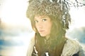 Portrait of a beautiful girl in a fur hat in backl